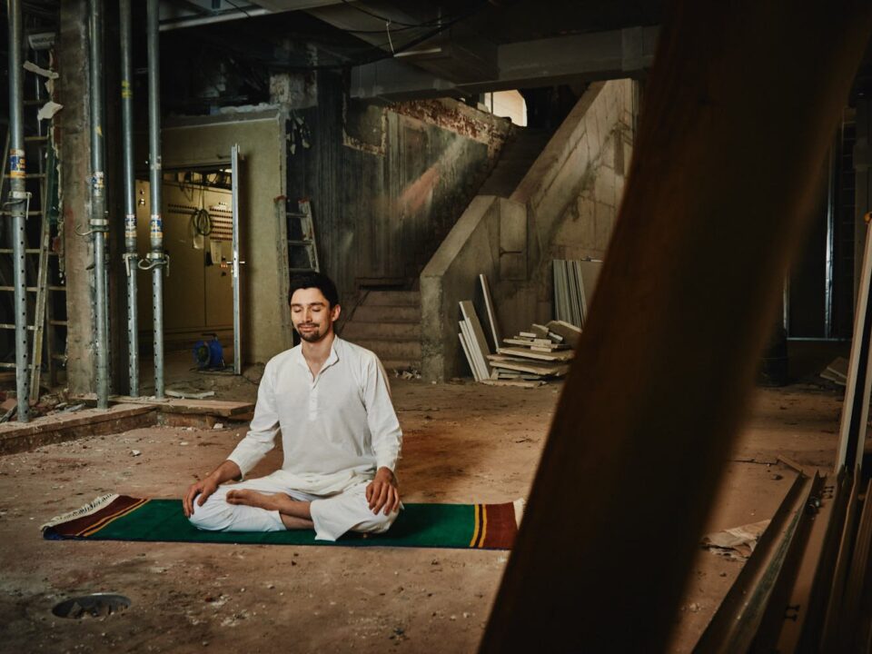 Joram Schirmaier sitzt meditativ im Freien und fokussiert sein Sankalpa, die bewusste Absicht.